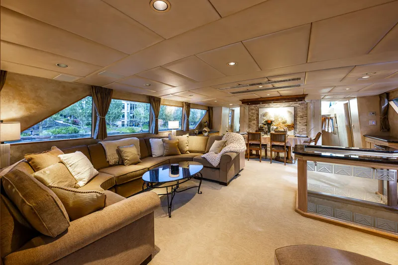 Slide: The Image of Luxurious interior of 1991 Broward 102 yacht with elegant seating and dining area. - 14