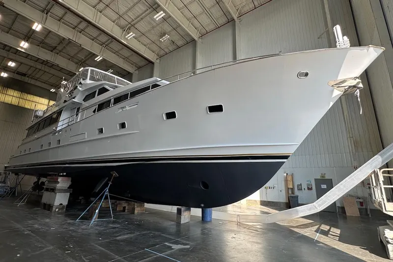 Slide: The Image of Luxury yacht Broward 102, 1991 model, in a spacious indoor facility. - 85