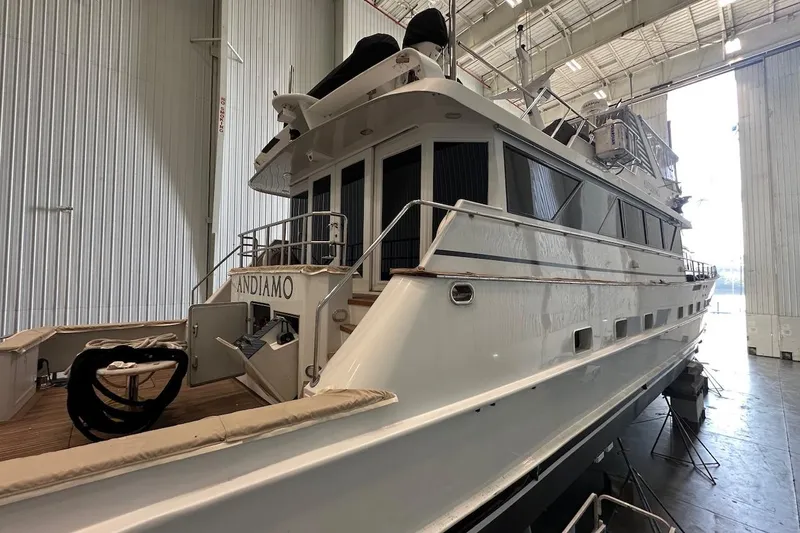 Slide: The Image of Luxury yacht Broward 102, 1991 model, docked in a spacious indoor marina. - 87