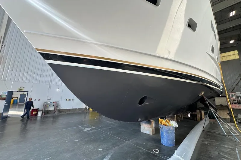 Slide: The Image of Broward 102 yacht from 1991 in a maintenance facility, showcasing its sleek hull design. - 90