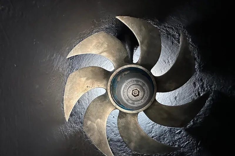 Slide: The Image of Bronze propeller of a 1991 Broward 102 yacht, showcasing intricate blade design. - 92
