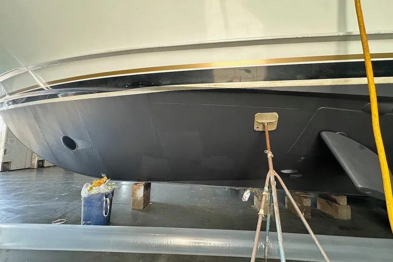 Slide: The Image of Bottom view of a 1991 Broward 102 yacht in a maintenance facility. - 94