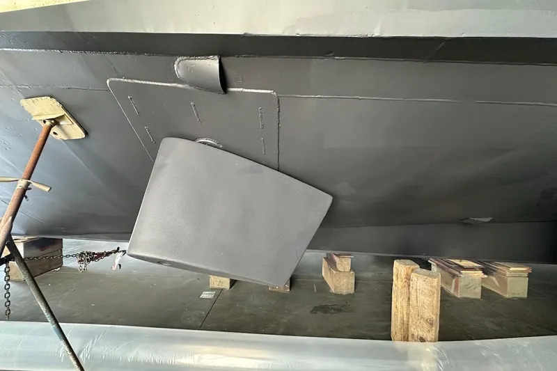 Slide: The Image of Bottom view of a 1991 Broward 102 yacht with visible rudder and support blocks. - 95