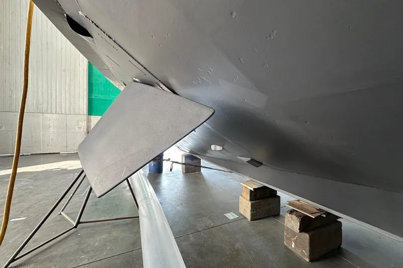 Slide: The Image of Underside view of a 1991 Broward 102 yacht in a maintenance facility. - 96