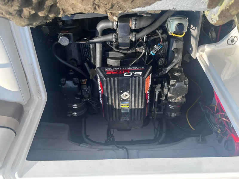 Slide: The Image of Engine compartment of a 1999 Chaparral 210 Sunesta boat, showcasing the motor and components. - 13