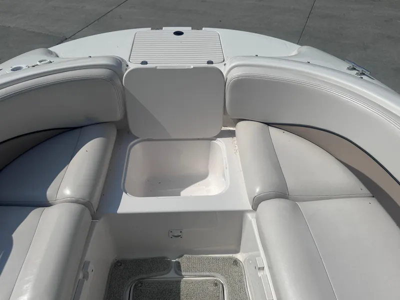 Slide: The Image of 1999 Chaparral 210 Sunesta boat interior with white seating and storage compartment. - 17