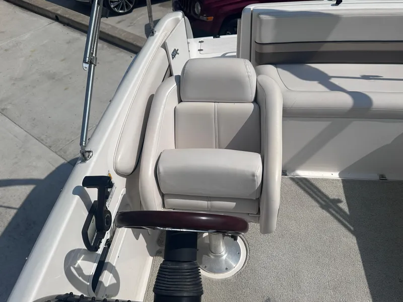 Slide: The Image of 1999 Chaparral 210 Sunesta boat interior with white captain's chair and steering wheel. - 22