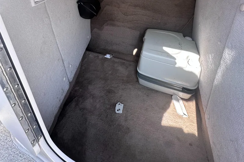 Slide: The Image of Interior storage compartment of a 1999 Chaparral 210 Sunesta boat with portable toilet. - 27
