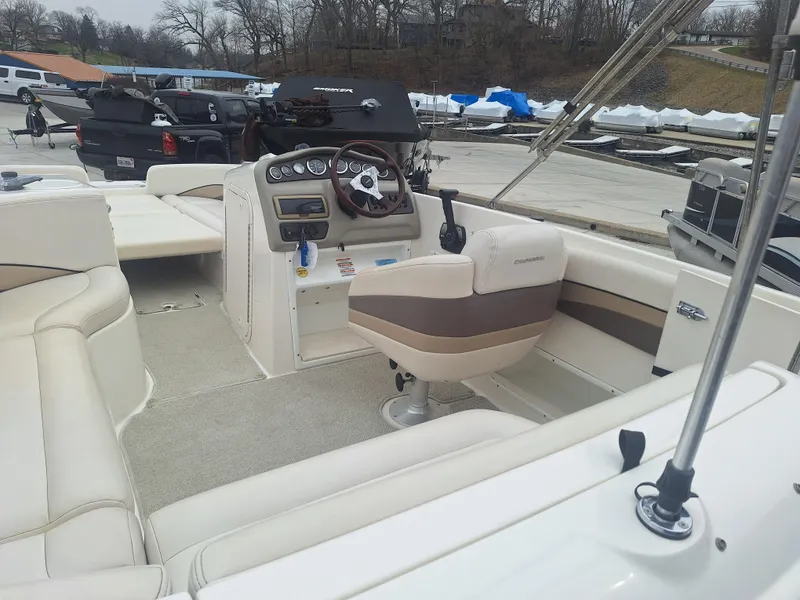 Slide: The Image of 1999 Chaparral 210 Sunesta boat interior with beige seating and steering console. - 39