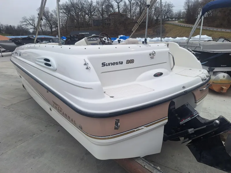 Slide: The Image of 1999 Chaparral 210 Sunesta boat, white and beige, docked outdoors on a cloudy day. - 41