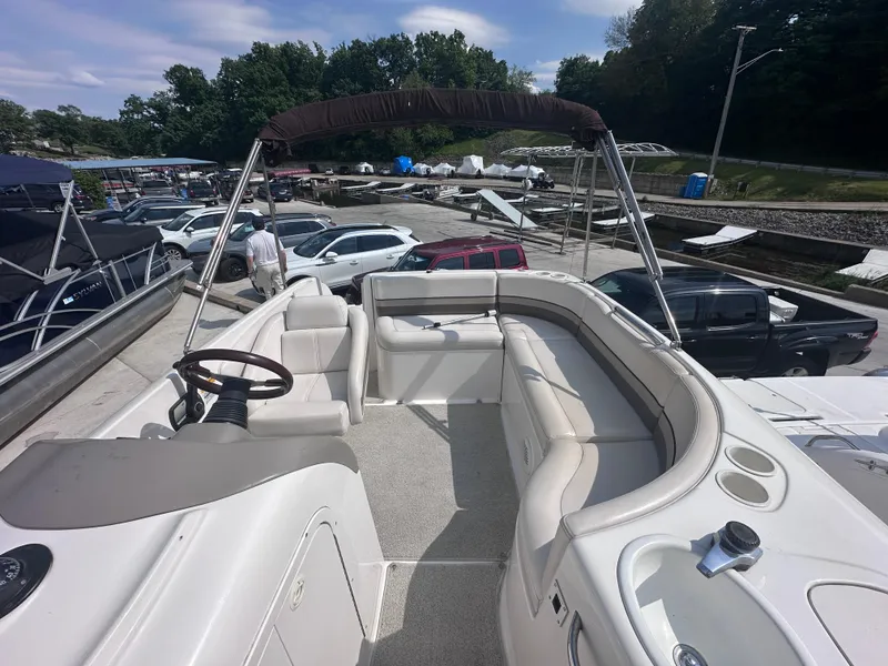 Slide: The Image of 1999 Chaparral 210 Sunesta boat interior with seating and steering wheel, docked at marina. - 8