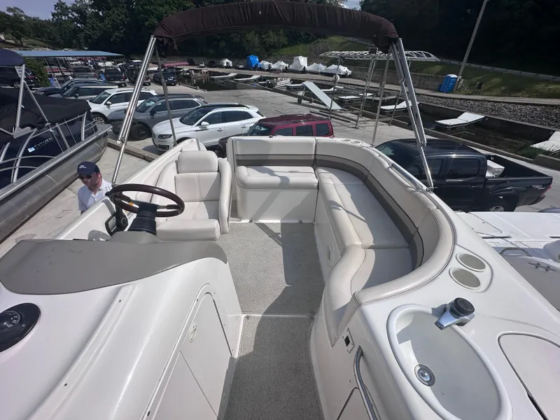 Slide: The Image of 1999 Chaparral 210 Sunesta boat interior with seating and steering wheel, docked at marina. - 9