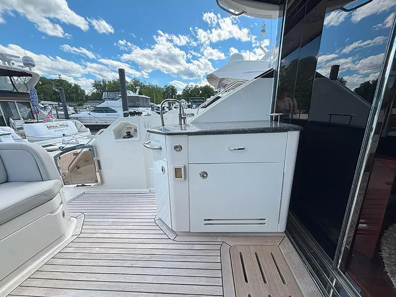 Slide: The Image of 2017 Sea Ray L590 yacht deck with outdoor kitchenette and seating area. - 23