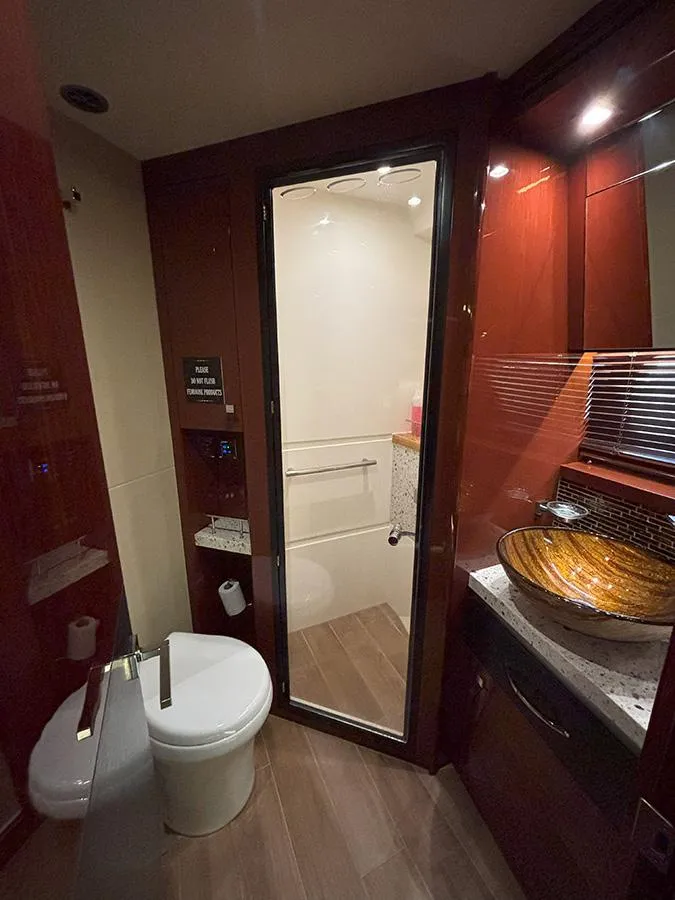 Slide: The Image of Luxurious bathroom in 2017 Sea Ray L590 yacht with modern fixtures and elegant wood finishes. - 42