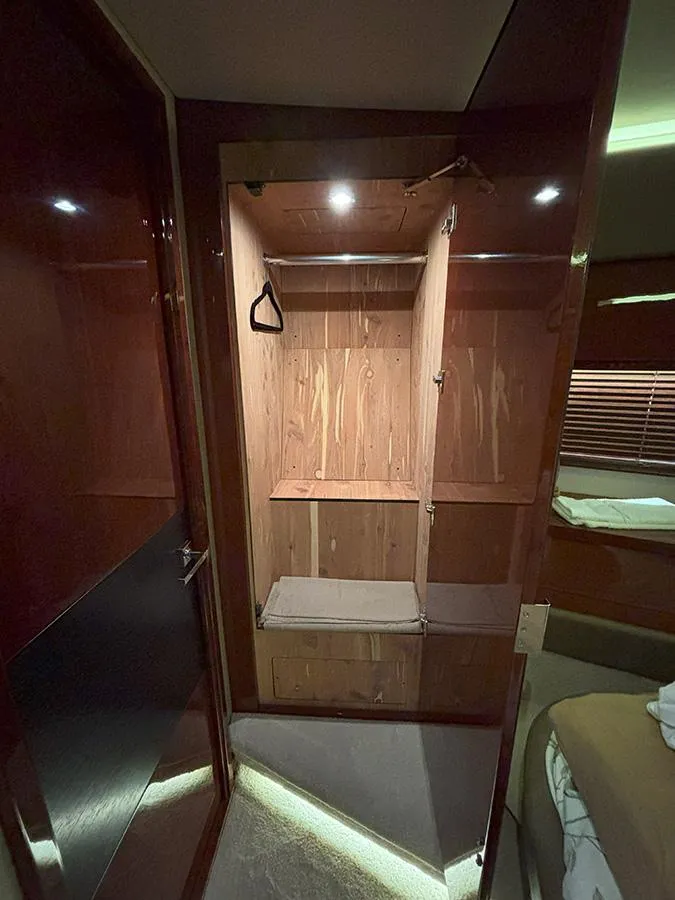Slide: The Image of 2017 Sea Ray L590 yacht interior closet with wooden finish and lighting. - 45