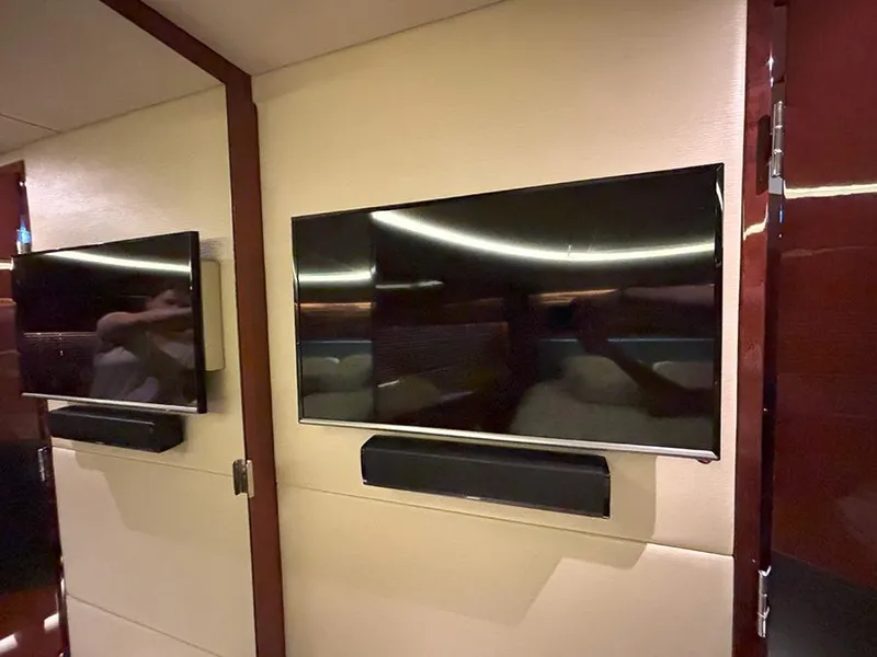 Slide: The Image of Flat-screen TVs inside 2017 Sea Ray L590 yacht interior, featuring modern design and wood accents. - 47