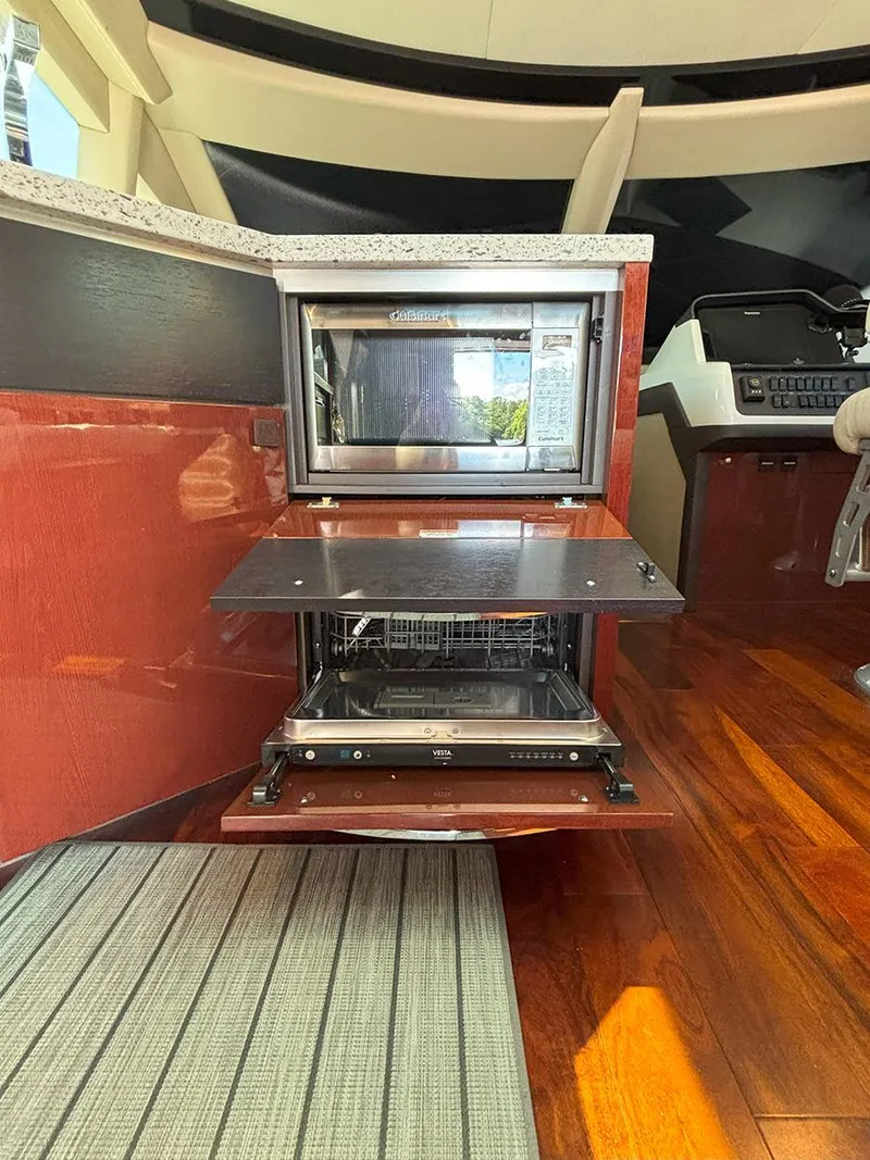 Slide: The Image of 2017 Sea Ray L590 yacht interior with modern kitchen appliances and wooden flooring. - 9