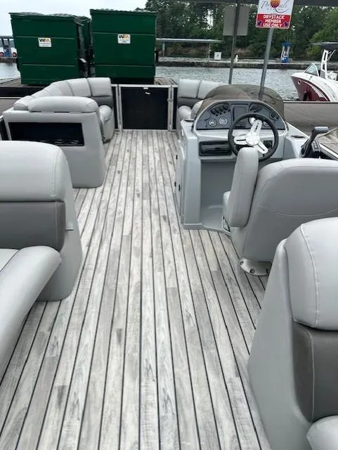 Slide: The Image of 2015 Silver Wave 230 Island CL pontoon boat with gray seating and wooden deck. - 10