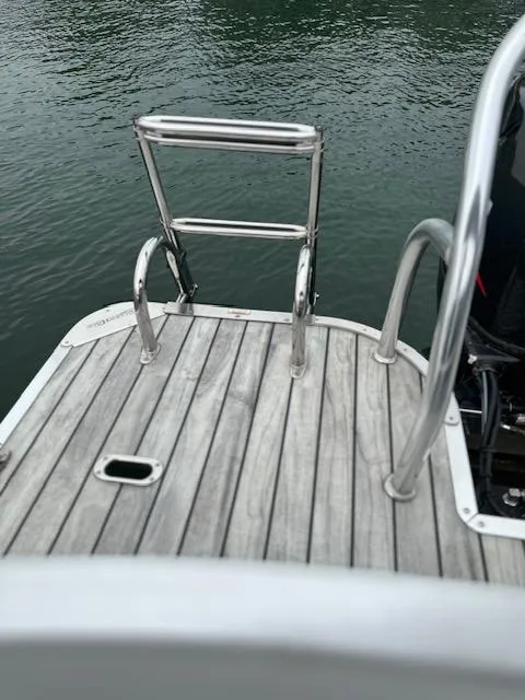 Slide: The Image of 2015 Silver Wave 230 Island CL boat with wooden deck and stainless steel ladder. - 14