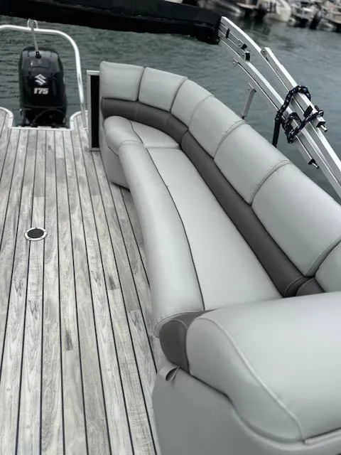 Slide: The Image of 2015 Silver Wave 230 Island CL boat with gray seating and wooden deck. - 7