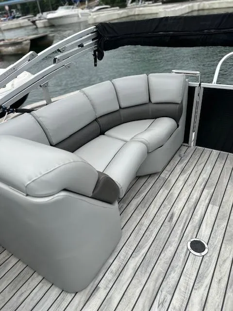 Slide: The Image of 2015 Silver Wave 230 Island CL boat with gray seating on wooden deck. - 8