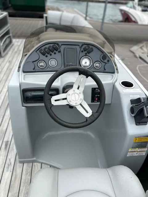 Slide: The Image of 2015 Silver Wave 230 Island CL boat dashboard with steering wheel and controls. - 9