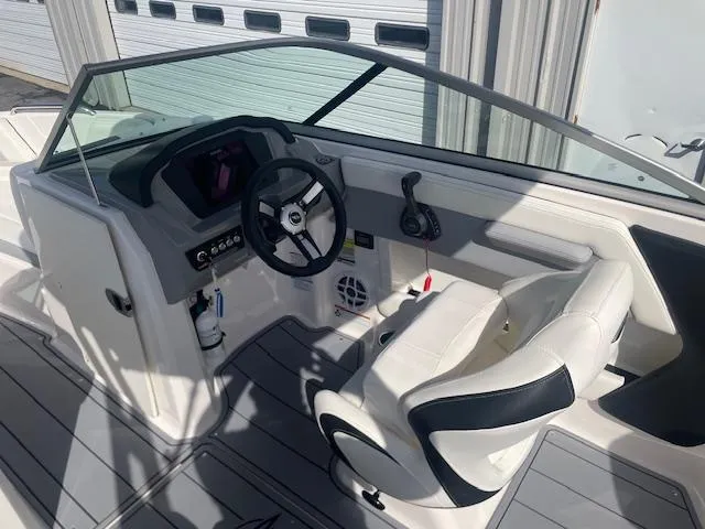 Slide: The Image of 2022 Chaparral 21 Surf boat interior with steering console and seating. - 11