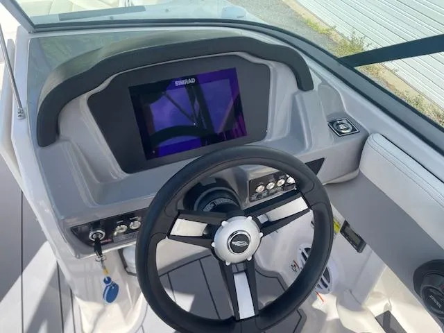 Slide: The Image of 2022 Chaparral 21 Surf boat interior with steering wheel and captain's seat. - 12