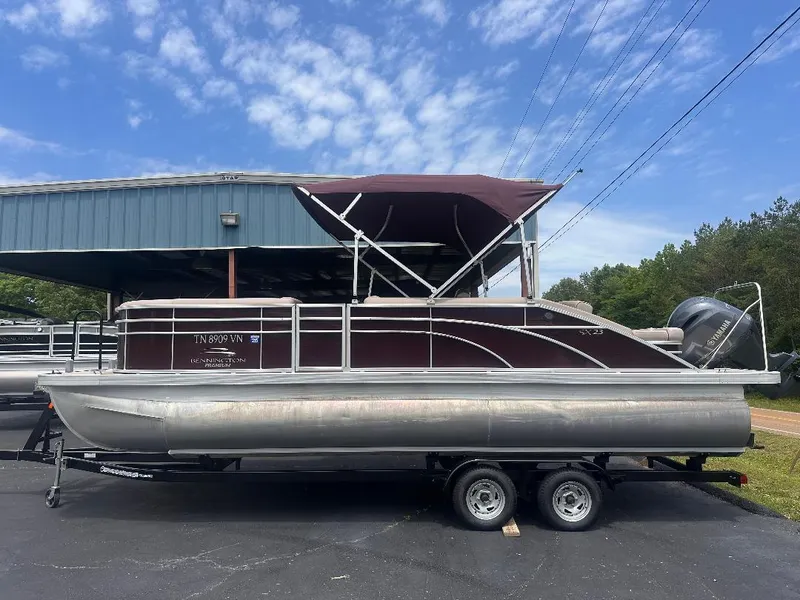 Slide: The Image of 2018 Bennington 23SSBXP pontoon boat with Yamaha F150, parked on a trailer. - 1