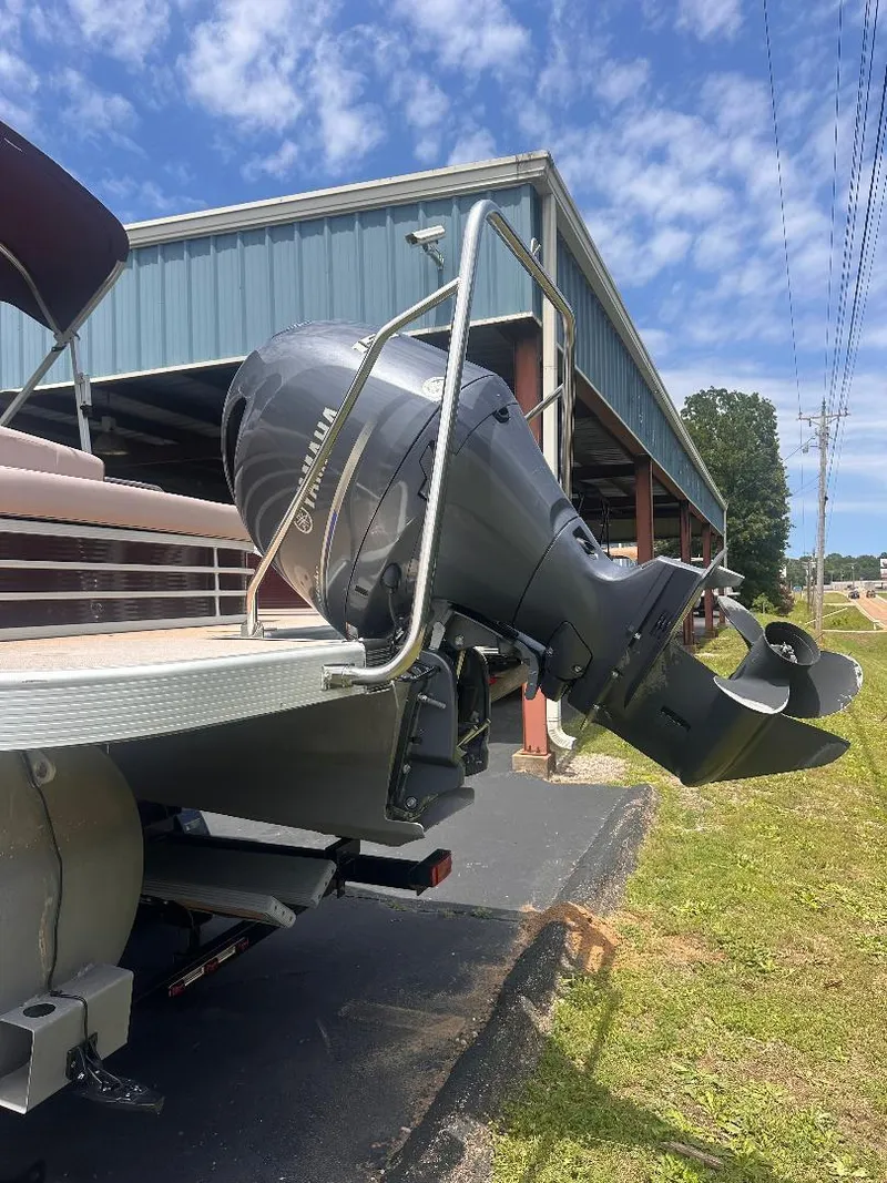 Slide: The Image of 2018 Bennington 23SSBXP boat with Yamaha F150 engine, parked outdoors. - 2