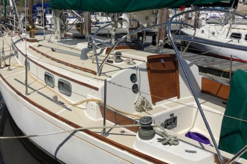 Slide: The Image of 1981 Sea Sprite 34 sailboat docked, featuring classic design and green sail covers. - 2