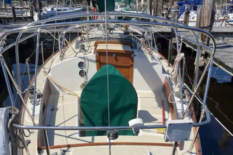 Slide: The Image of 1981 Sea Sprite 34 sailboat docked, featuring a spacious deck and green cover. - 3