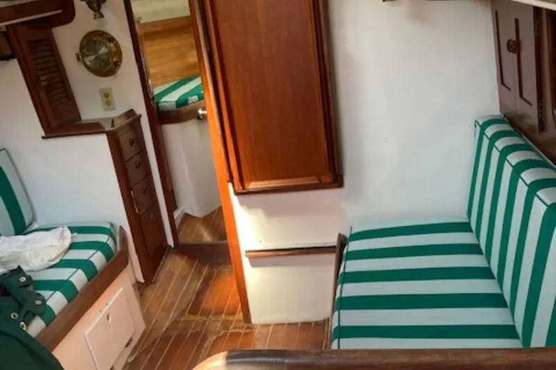 Slide: The Image of Interior of 1981 Sea Sprite 34 sailboat with striped green cushions and wooden cabinetry. - 7