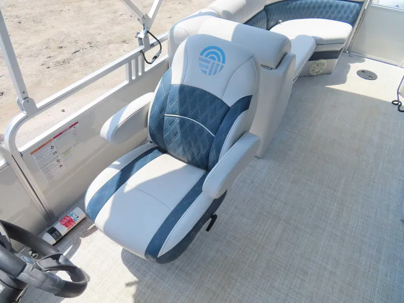 Slide: The Image of 2022 Nepallo pontoon boat interior with blue and white seating, steering wheel visible. - 18