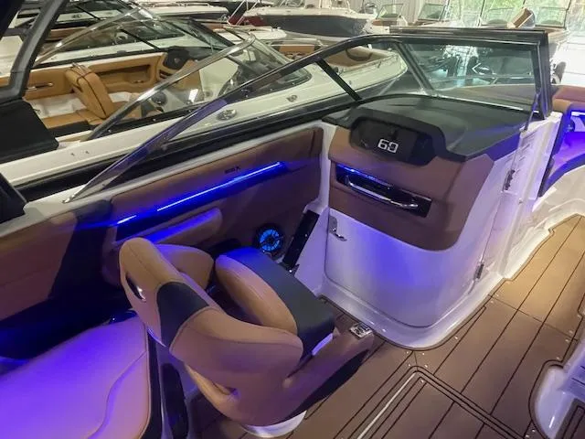 Slide: The Image of 2025 Chaparral 267 SSX boat interior with modern dashboard and ambient lighting. - 11