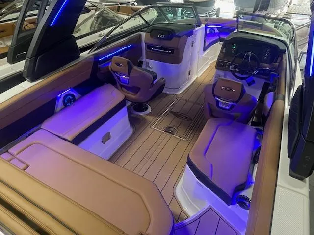Slide: The Image of 2025 Chaparral 267 SSX boat interior with luxurious seating and ambient blue lighting. - 6
