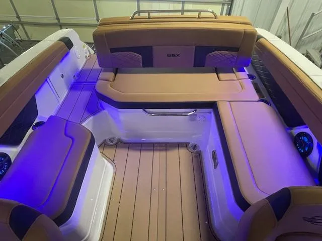 Slide: The Image of 2025 Chaparral 267 SSX boat interior with tan seating and blue ambient lighting. - 7