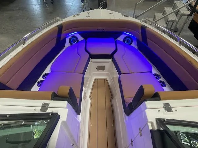 Slide: The Image of 2025 Chaparral 267 SSX boat interior with blue LED lighting and tan seating. - 9