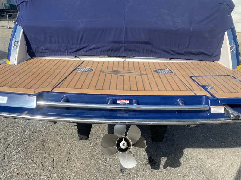 Slide: The Image of 2018 Chaparral 267 SSX boat stern with teak swim platform and propeller. - 15