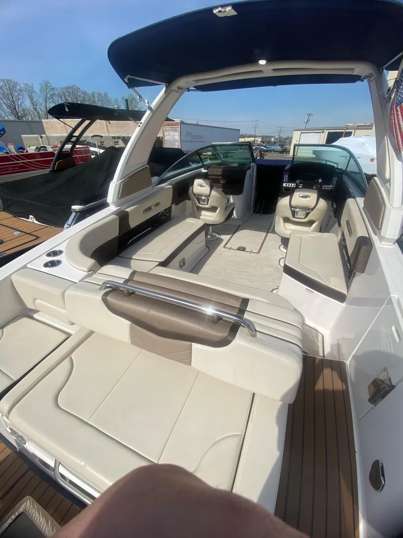 Slide: The Image of 2018 Chaparral 267 SSX boat interior with seating and helm, under a blue sky. - 9