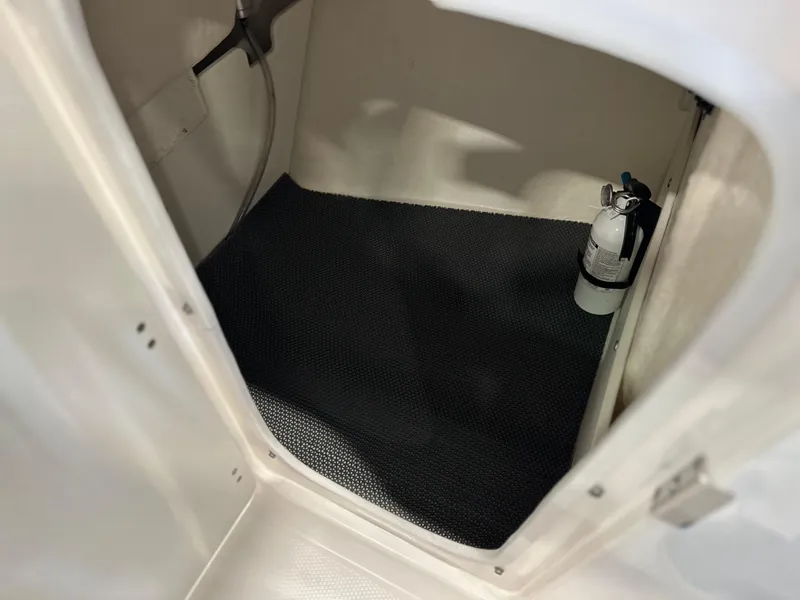 Slide: The Image of 2019 Robalo R207 Dual Console storage compartment with fire extinguisher. - 14