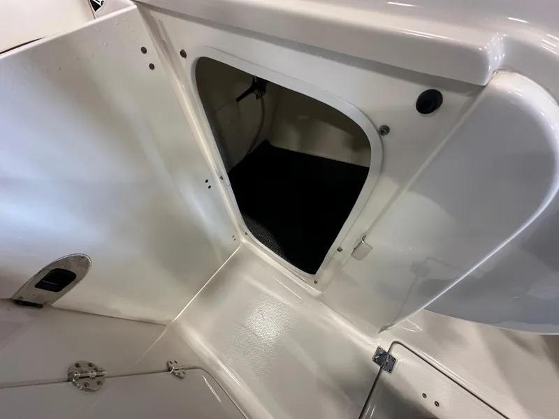 Slide: The Image of 2019 Robalo R207 Dual Console storage compartment, white interior, open hatch. - 15