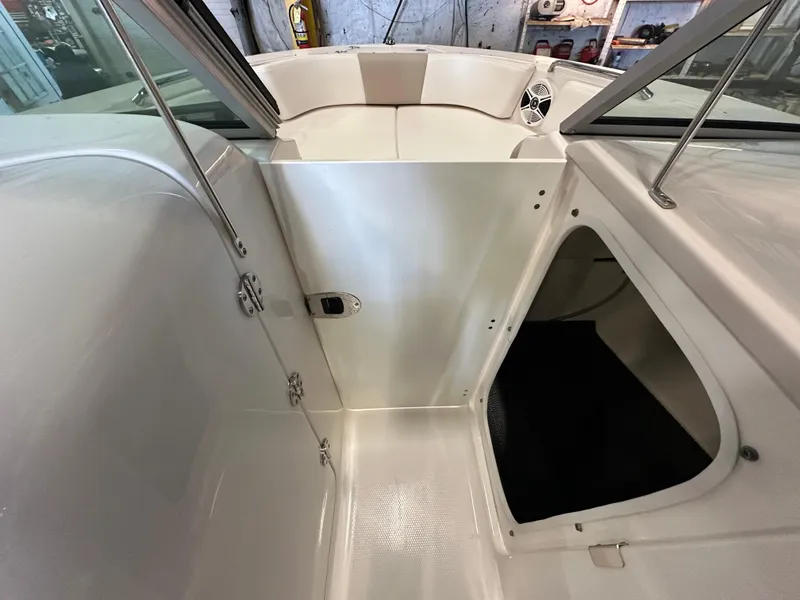 Slide: The Image of 2019 Robalo R207 Dual Console interior, featuring seating and storage compartment. - 16