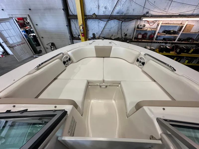 Slide: The Image of 2019 Robalo R207 Dual Console boat interior with white seating in a garage setting. - 17