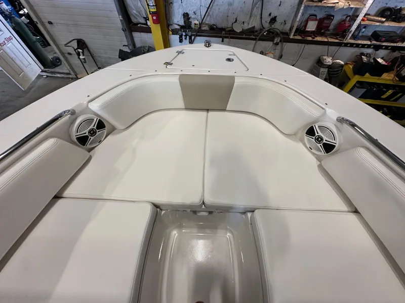 Slide: The Image of 2019 Robalo R207 Dual Console boat interior with white cushioned seating and speakers. - 18
