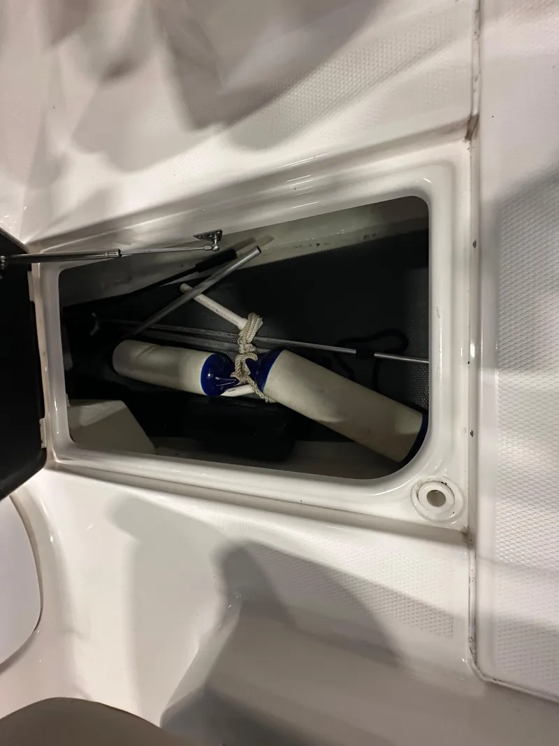 Slide: The Image of 2019 Robalo R207 Dual Console storage compartment with boating equipment. - 21