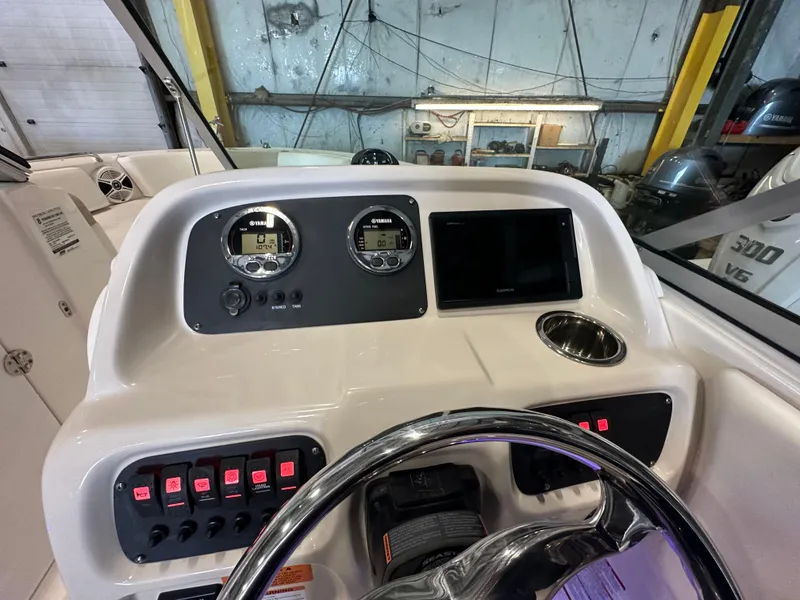 Slide: The Image of 2019 Robalo R207 Dual Console dashboard with gauges, switches, and steering wheel in a garage setting. - 24