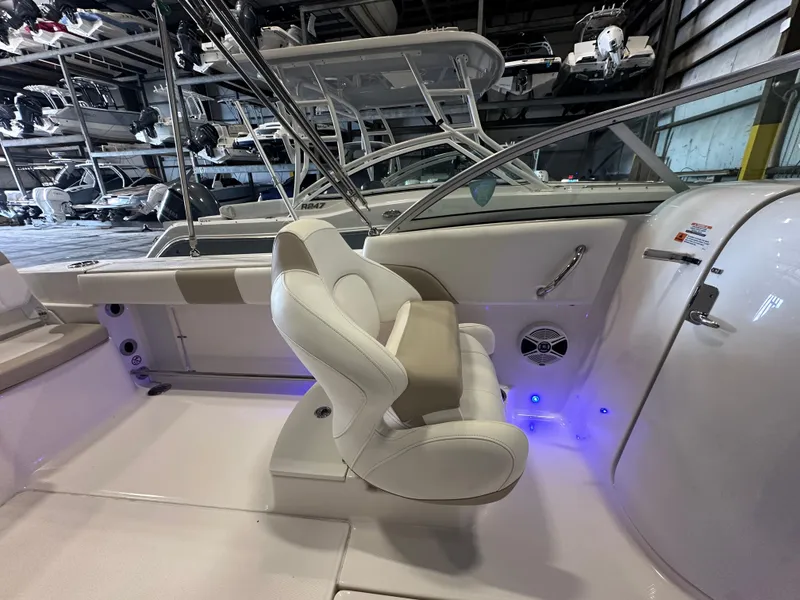 Slide: The Image of 2019 Robalo R207 Dual Console boat interior with white seating and blue accent lighting. - 25