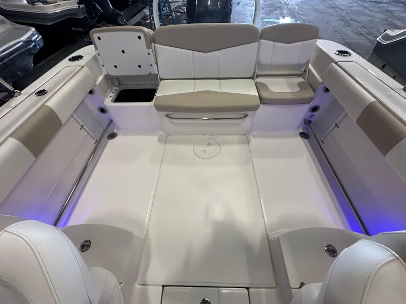 Slide: The Image of 2019 Robalo R207 Dual Console boat interior with white seating and blue accent lighting. - 26