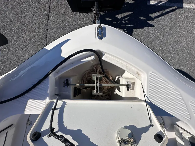 Slide: The Image of 2017 Yamaha Boats 190 FSH Sport bow storage compartment with anchor and rope. - 14